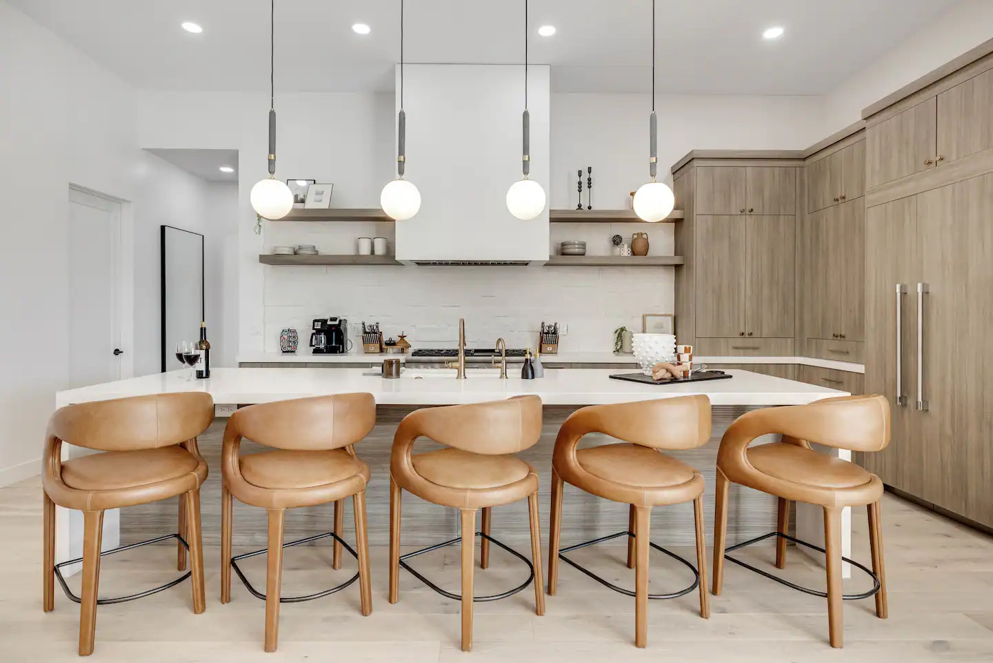 Modern kitchen with leather barstools and pendant lighting